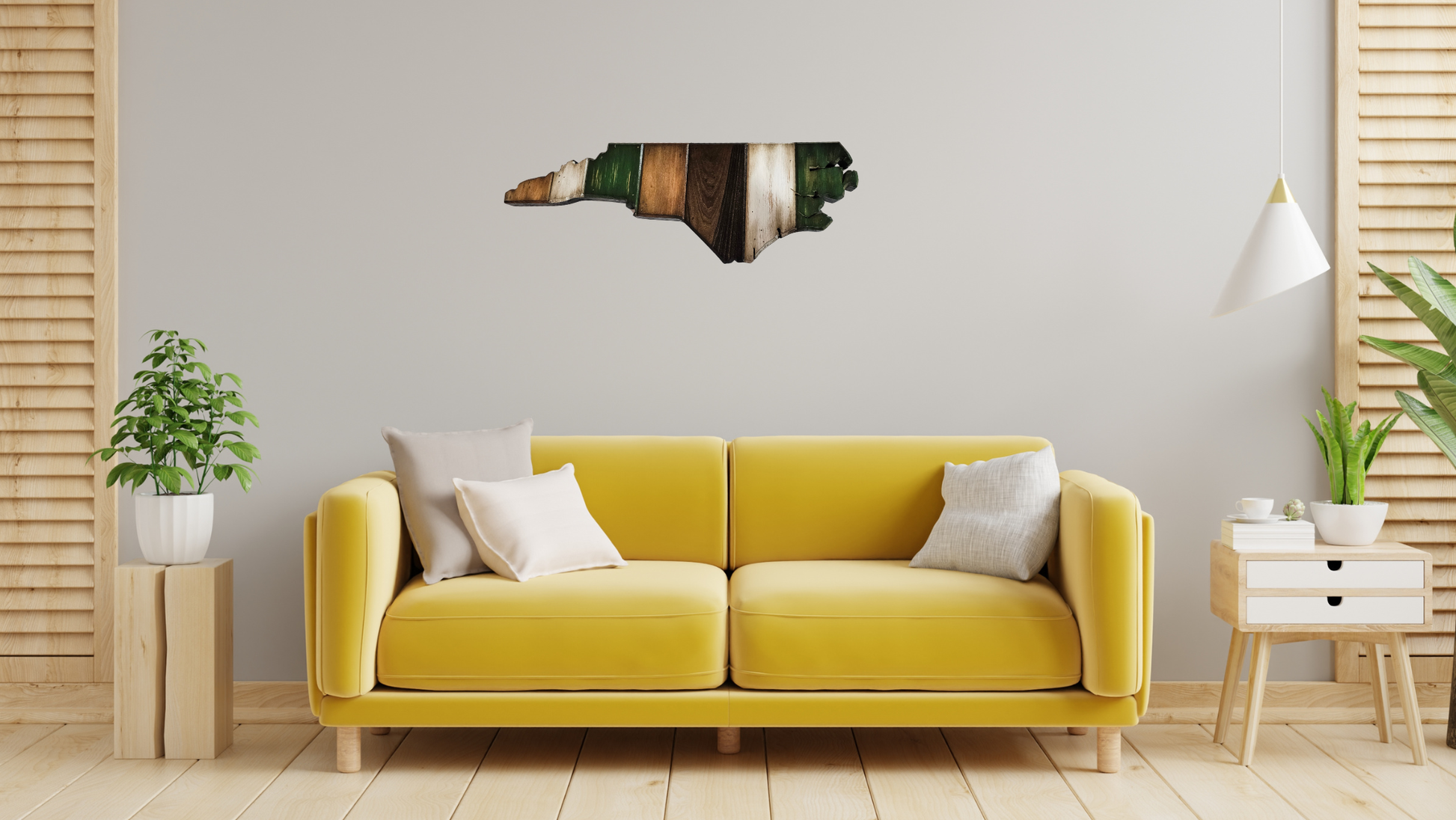 Handmade, rustic, large wooden North Carolina wall art hanging on the wall over the couch. The North Carolina wall art is dark green, white, dark walnut, and golden oak colors.