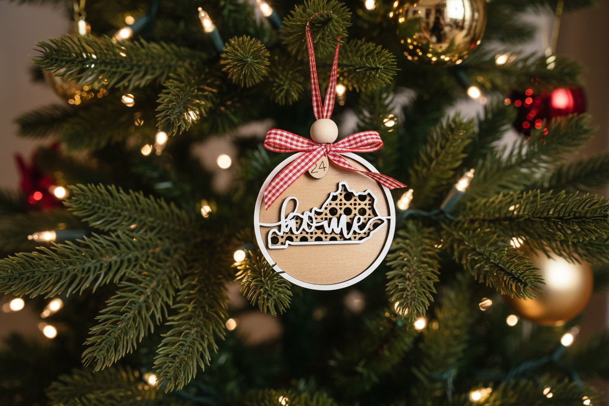 Decorative Kentucky ornament with 'home' text, red flower, and greenery on a white background