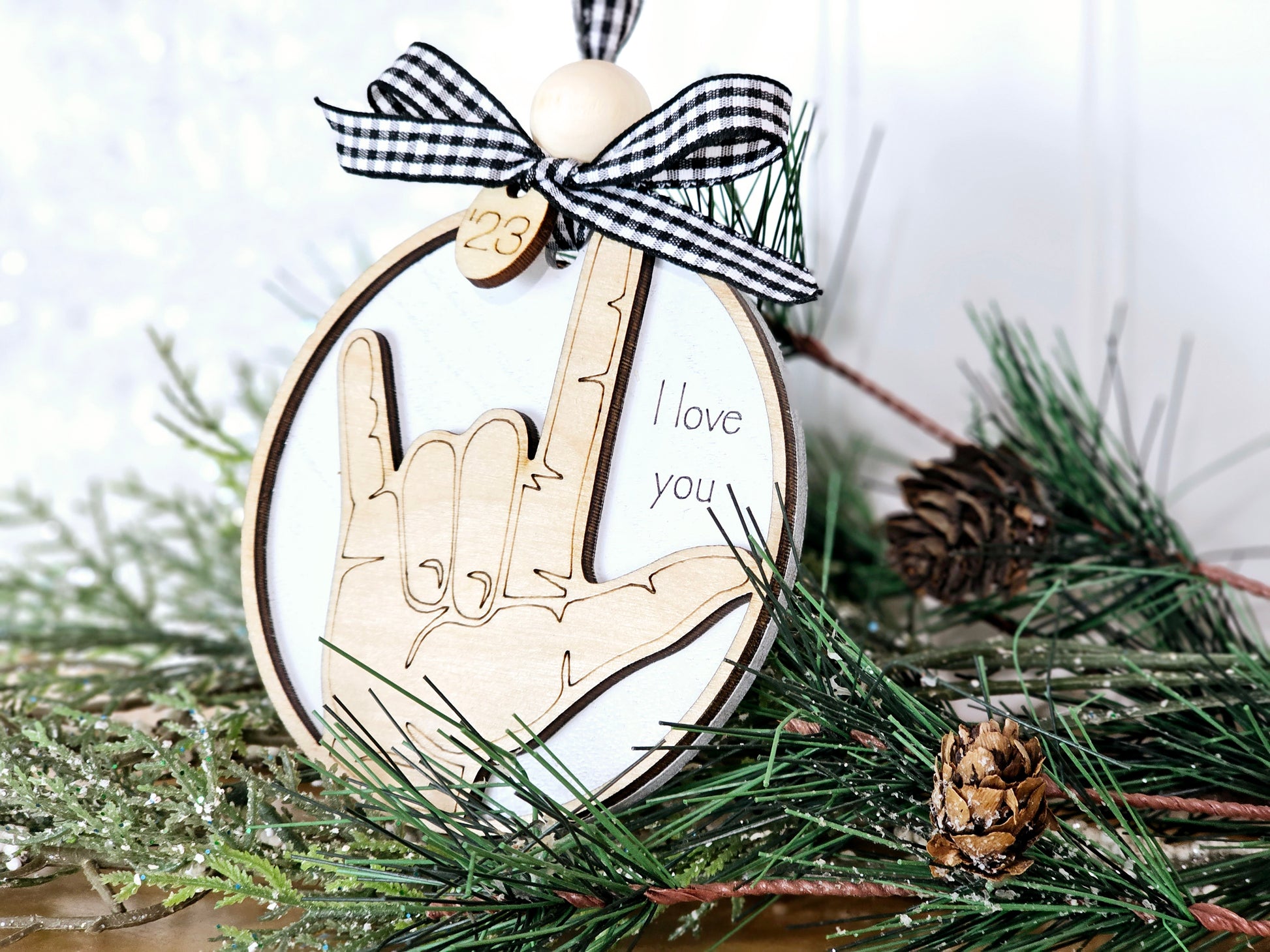 Close-up of ASL I Love You ornament showing hand sign detail and wood bead accent
