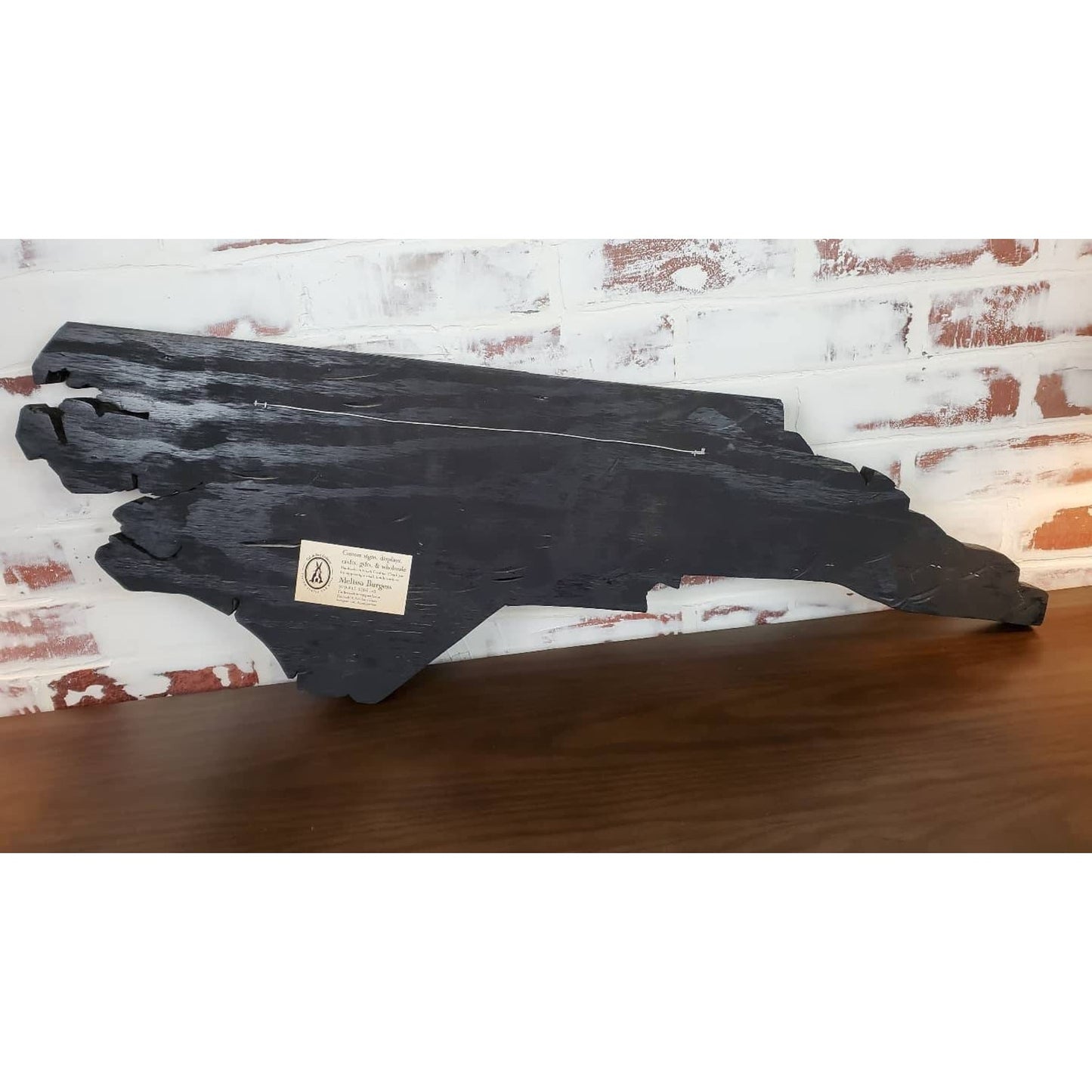 Back of wall art showing wire hanger and black painted backing for easy hanging
