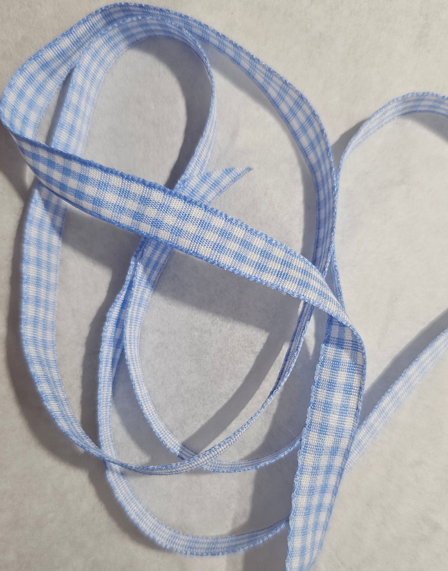 Blue and white checkered ribbon on a neutral background
