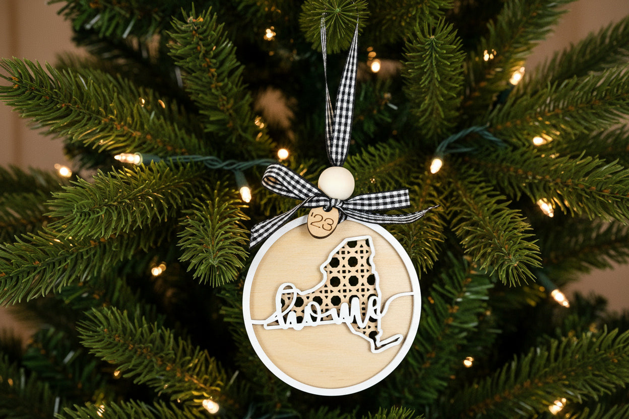 Decorative ornament with 'New York' shape and Home overlay on a Christmas tree
