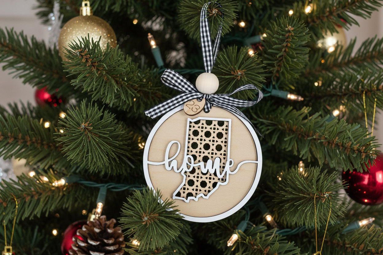 Decorative Christmas ornament with 'home' and Indiana shape on a tree.