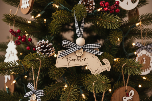 Massachusetts State-shaped Christmas ornaments with buffalo plaid ribbons and personalized town names, handmade birch wood keepsakes.
