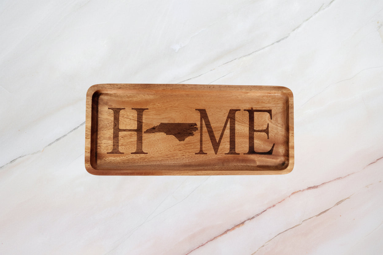 Wooden tray with 'HOME' engraving on a marble surface