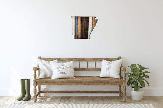 Wooden bench with decorative Arkansas wall art, pillows and a plant in a room