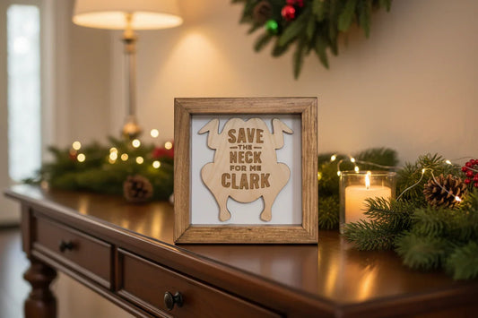 Wooden frame with a cutout of a turkey and text 'Save the Neck for me Clark' on a white background, inspired by the classic movie National Lampoon's Christmas Vacation.