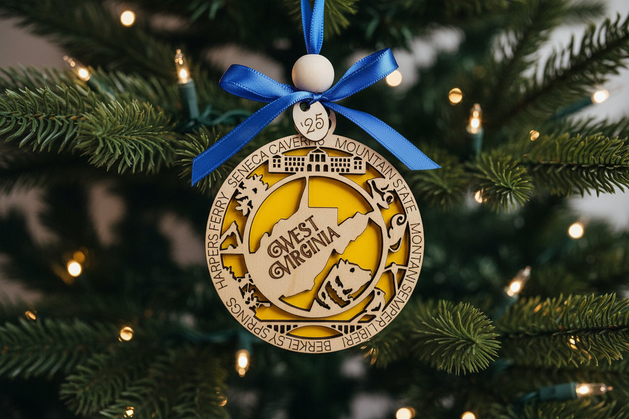 Decorative West Virginia ornament with blue ribbon hanging on a holiday tree.