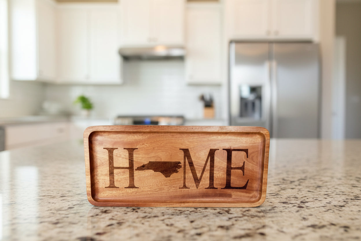 Wooden sign with 'HOME' engraved, featuring a state outline, on a wooden surface with a blurred bookshelf background.