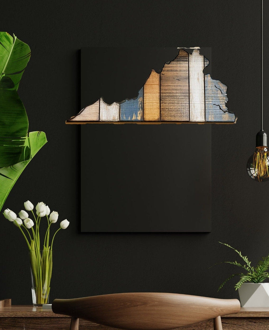 Wooden wall art of a Virginia shape on a black wall with a vase of white flowers and green leaves.
