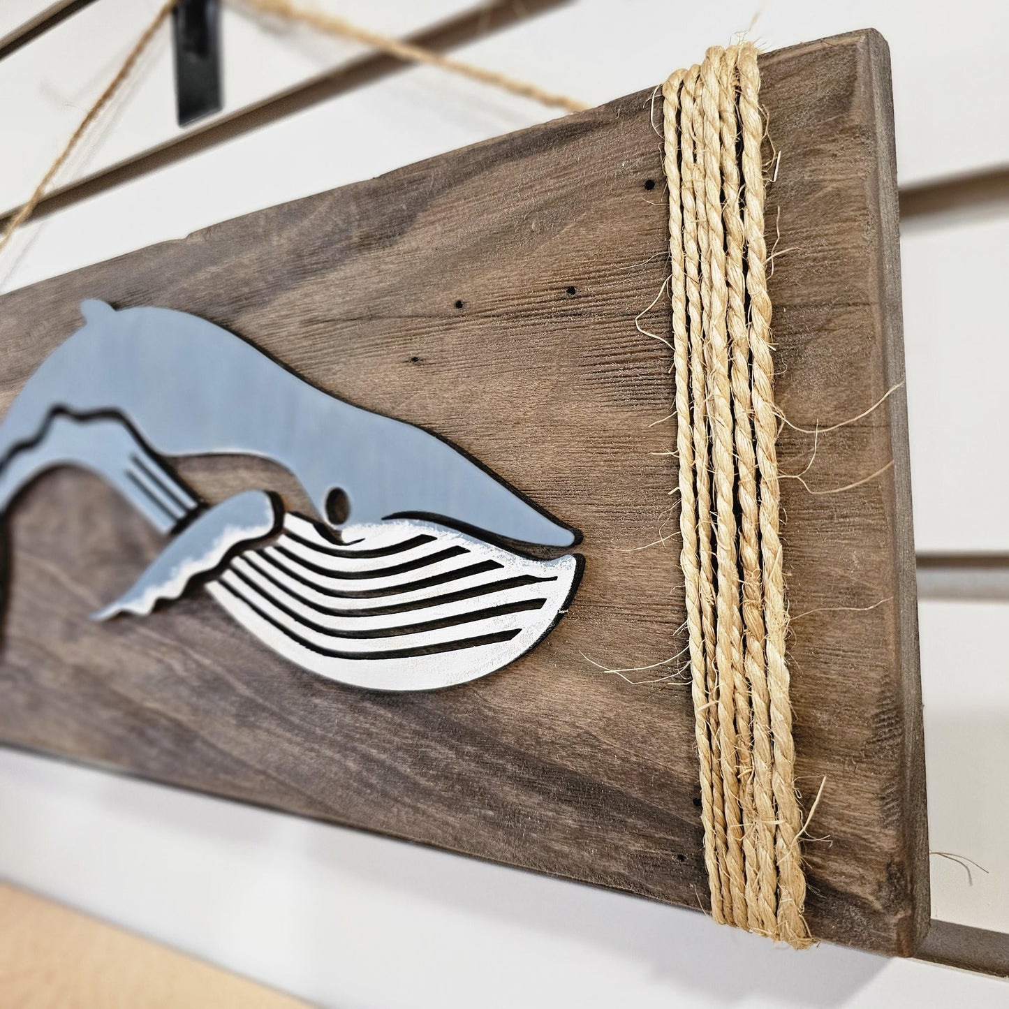 Close-up of rustic humpback whale wood wall art showing handcrafted detail and rope hanging hardware