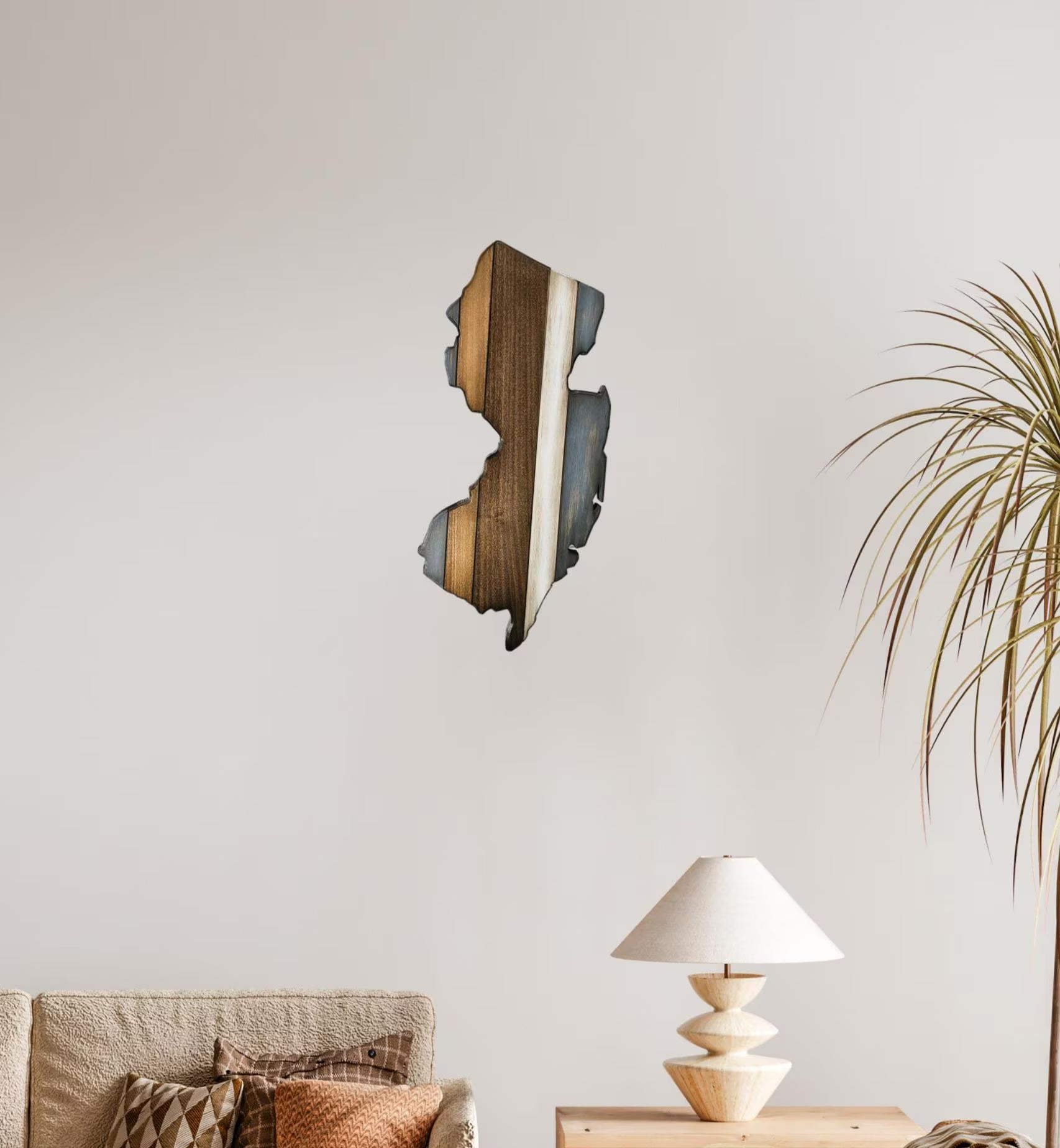 Wooden New Jersey wall art piece on a neutral wall with a lamp and plant in the foreground