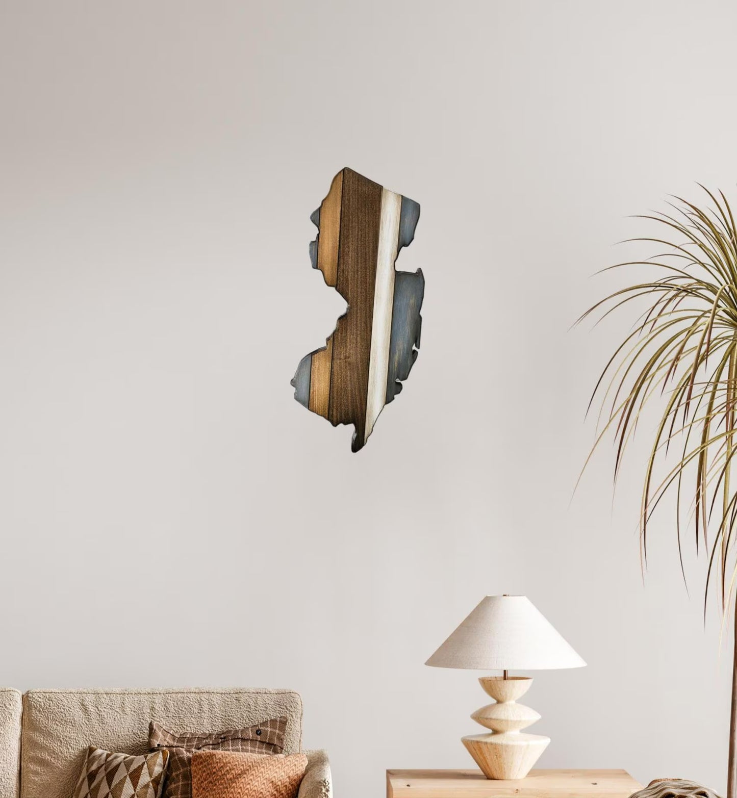 Wooden New Jersey wall art piece on a neutral wall with a lamp and plant in the foreground