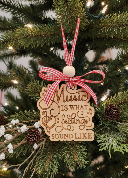 Music Christmas ornament with a music quote on a Christmas tree. "Music is what feelings sound like."