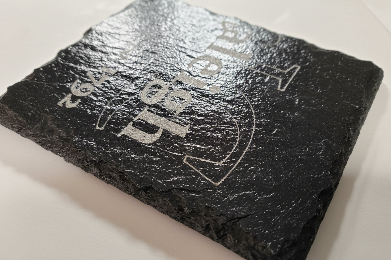 Close-up of engraved slate coaster showing detail and natural slate texture
