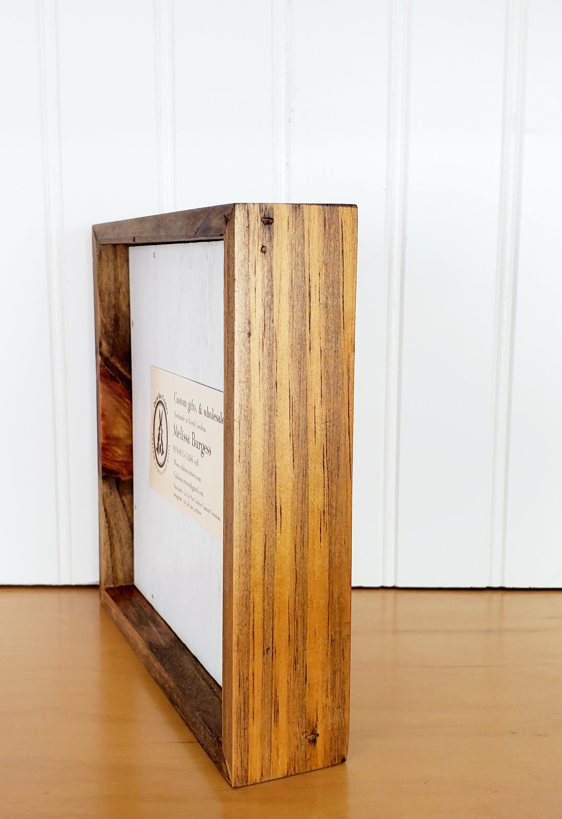 Paw print shaped wood sign with 1.5 inch frame, freestanding or wall hanging display side view.
