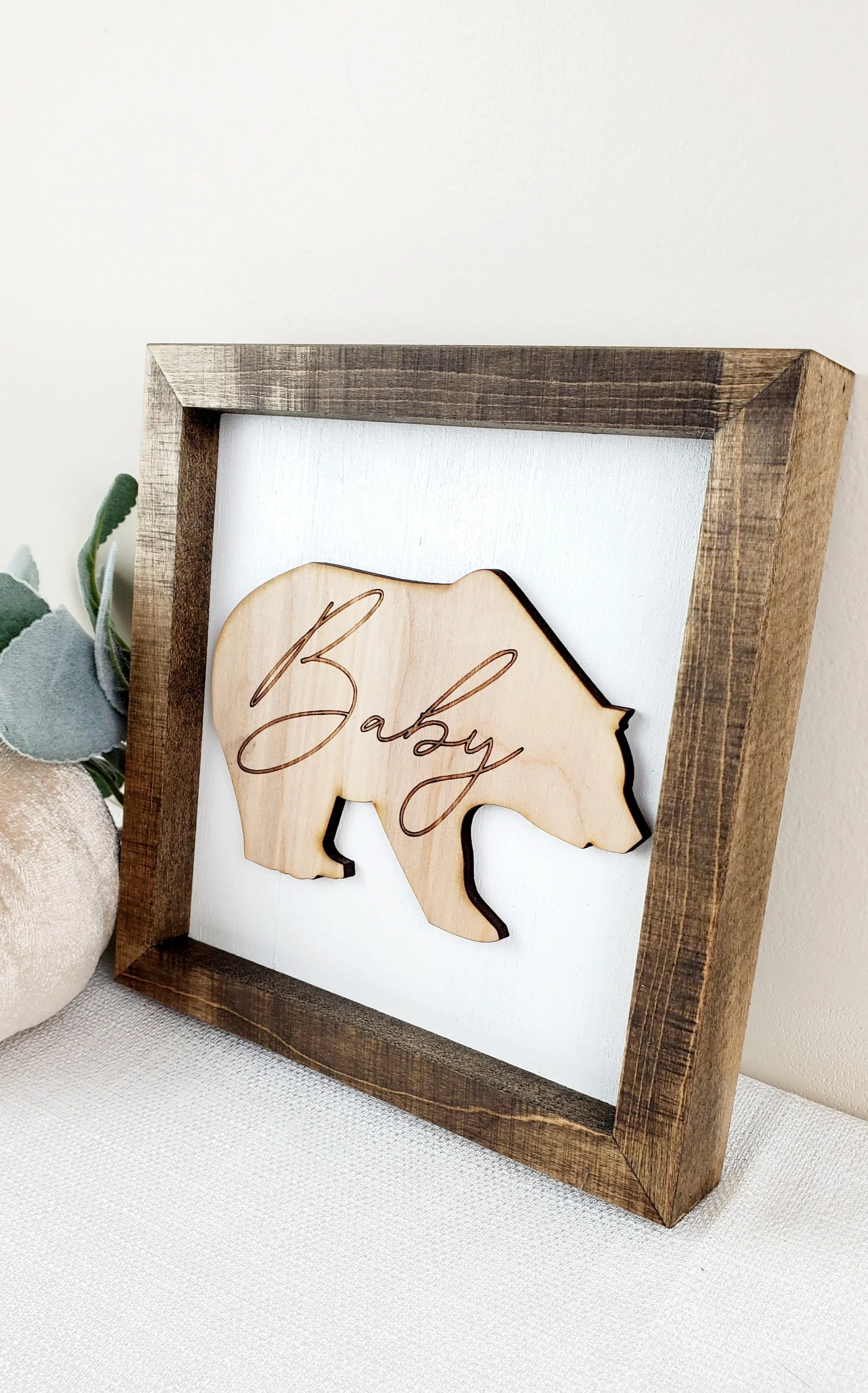 Wooden bear cutout with 'Baby' on a white background in a wooden frame.