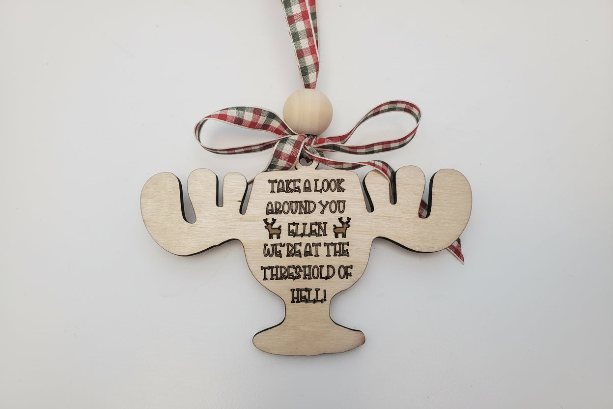 Wooden ornament shaped like a moose cup with text quote from National Lampoon's Christmas Vacation, and plaid ribbon on a white background