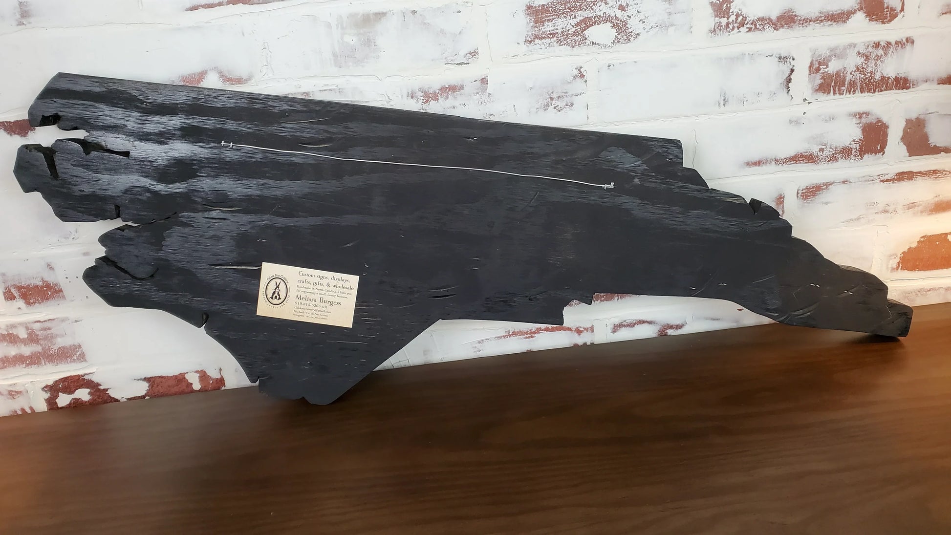 back of state wall art with business card glued to the back